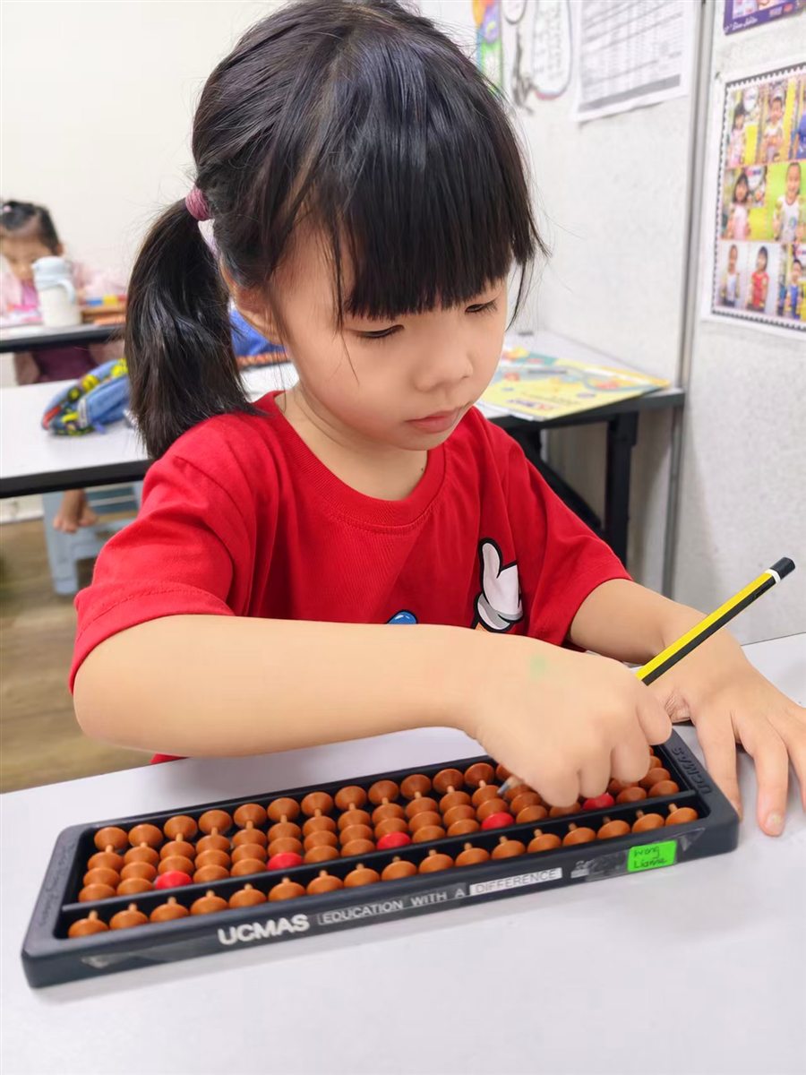 A student practising with a physical abacus at UCMAS Setia Alam